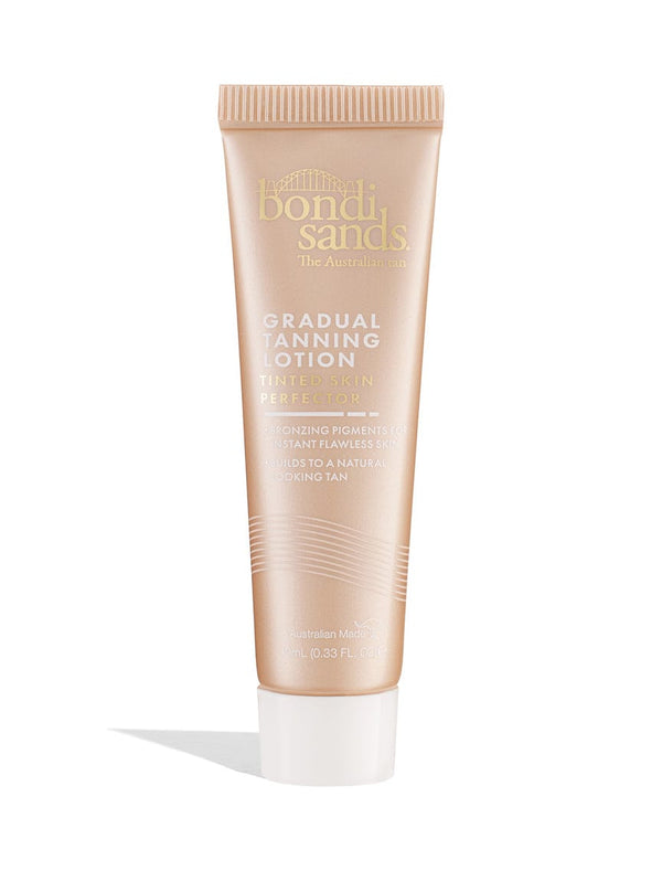 A beige tube of BondiSandsEU Tinted Skin Perfector Gradual Tanning Lotion Sample 10ML stands upright on a white background, featuring gold and white text and a screw cap. Get glowing skin with this gradual tanning lotion.