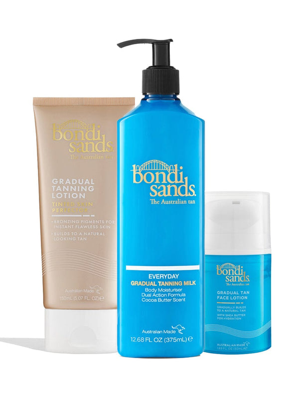 Three BondiSandsEU Gradual Essentials Bundle products are shown upright: a gold tanning lotion, a large blue pump bottle of everyday gradual tanning milk, and a smaller blue bottle of gradual face tan lotion.