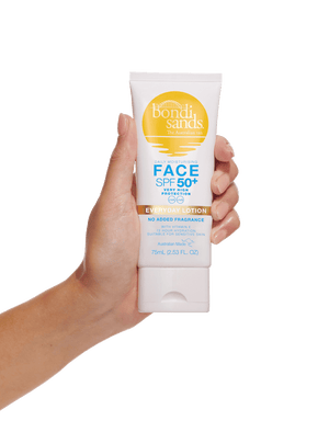 A hand holds a 75 ml tube of BondiSandsEU SPF 50+ Everyday Face Sunscreen Lotion, a water resistant daily moisturizer in a white tube with yellow and blue text for high sun protection.