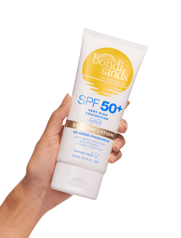 A hand holds a BondiSandsEU SPF 50+ Everyday Body Sunscreen Lotion tube, offering water resistant UVA & UVB protection, against a white background. The white tube has yellow and blue accents with product details on the front.