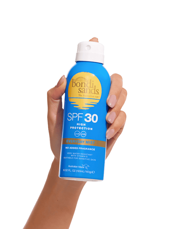 A hand holds a blue can of BondiSandsEU SPF 30 Everyday Sunscreen Aerosol Mist with yellow and white text against a plain white background, offering UVA/UVB protection for daily use.