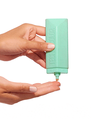 A person with medium skin tones dispenses BondiSandsEU Technocolor Emerald Self Tanning Face Serum from its rectangular green bottle onto their fingertip, holding the bottle in one hand to apply the natural tan serum to their face.