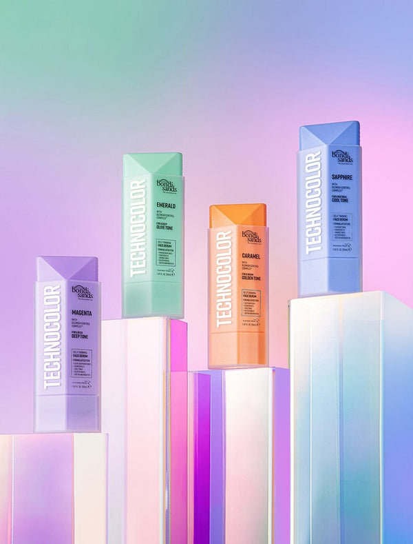 Four vibrant BondiSandsEU bottles labeled “TECHNICOLOR” stand on iridescent pedestals against a pastel backdrop. The Technocolor Magenta bottle highlights the Self Tanning Face Serum for a deep face tan; others show different product details.