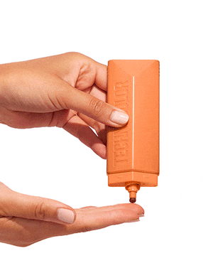 A hand holds an orange BondiSandsEU Technocolor Caramel Self Tanning Face Serum bottle, dispensing a small amount onto the other hand's fingers against a white background.