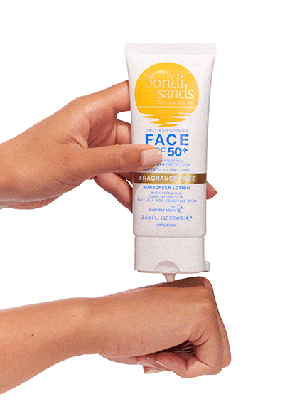 A hand dispenses BondiSandsEU Face SPF 50+ Fragrance Free Sunscreen Lotion onto another’s skin against a white background, spotlighting its non-comedogenic formula, ideal for sensitive skin.