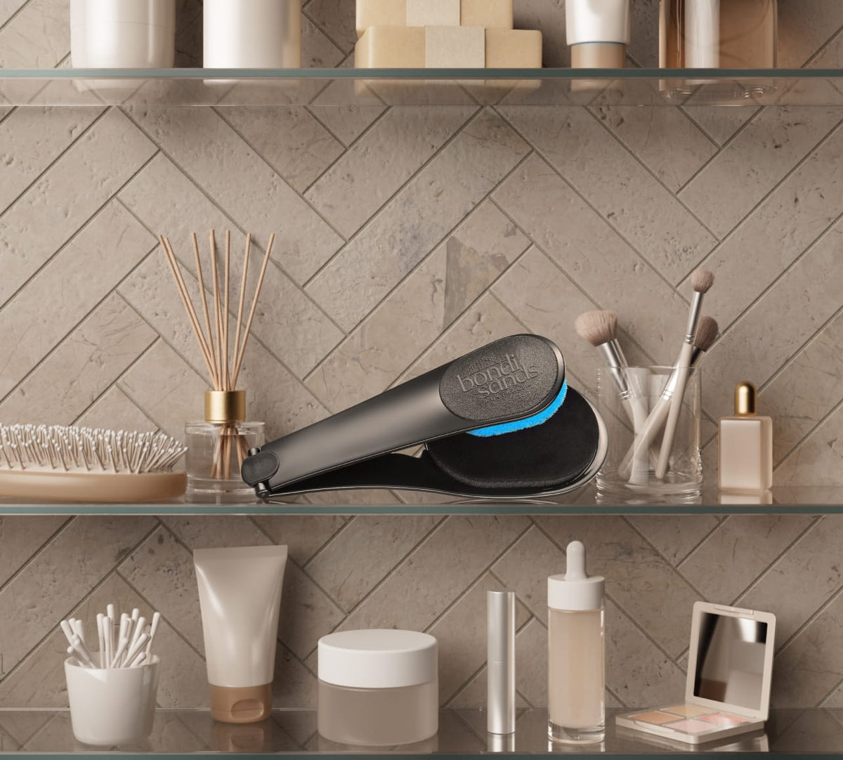 A bathroom shelf holds toiletries, makeup brushes, a comb, and the BondiSandsEU Back Applicator for a smooth tan. A reed diffuser adds style, while light herringbone tiles provide an elegant backdrop.