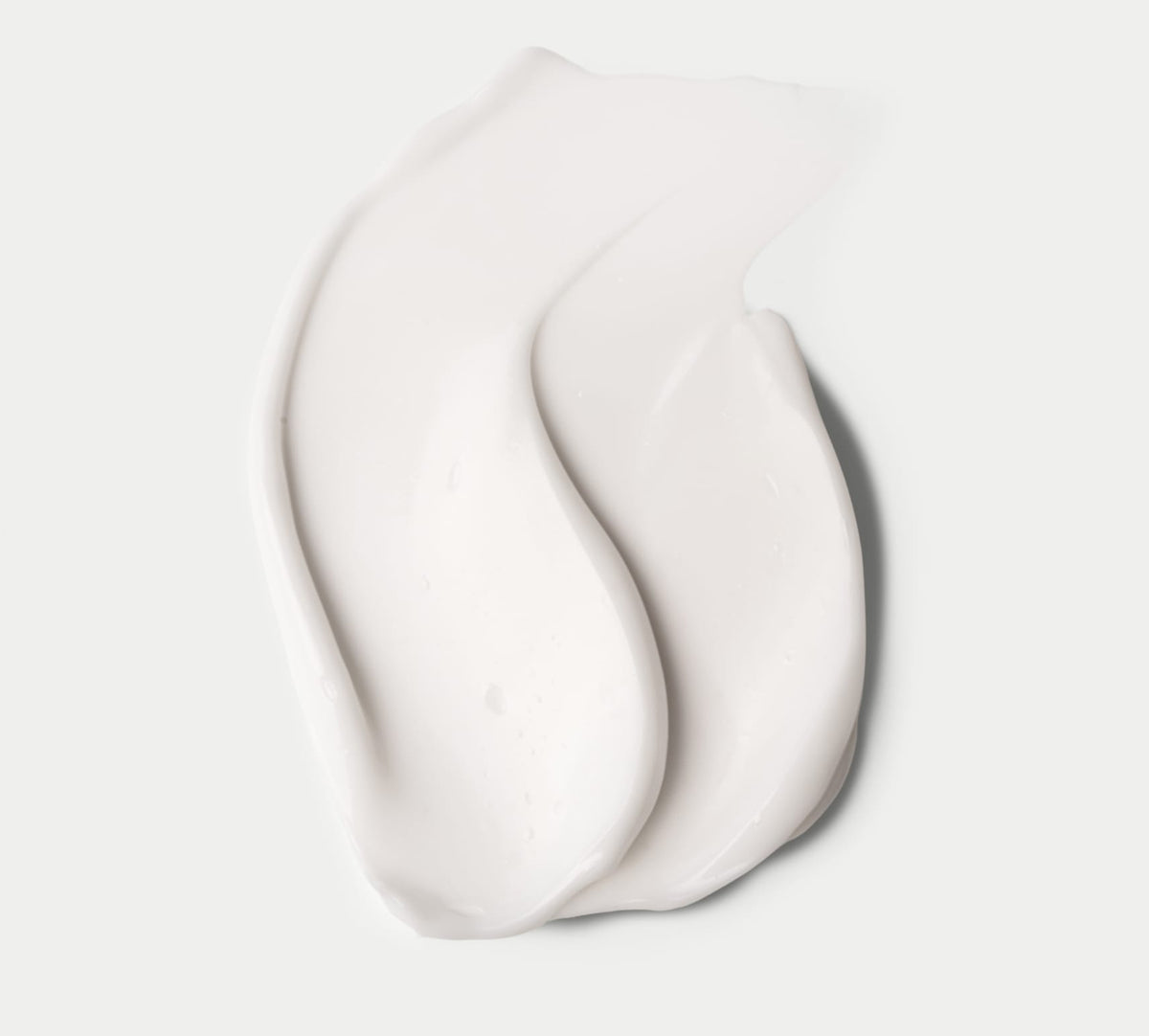 A close-up of BondiSandsEU Everyday Gradual Tanning Milk, swatched on a white background, shows its creamy texture and glossy finish that hint at rich hydration for a daily, natural-looking glow.