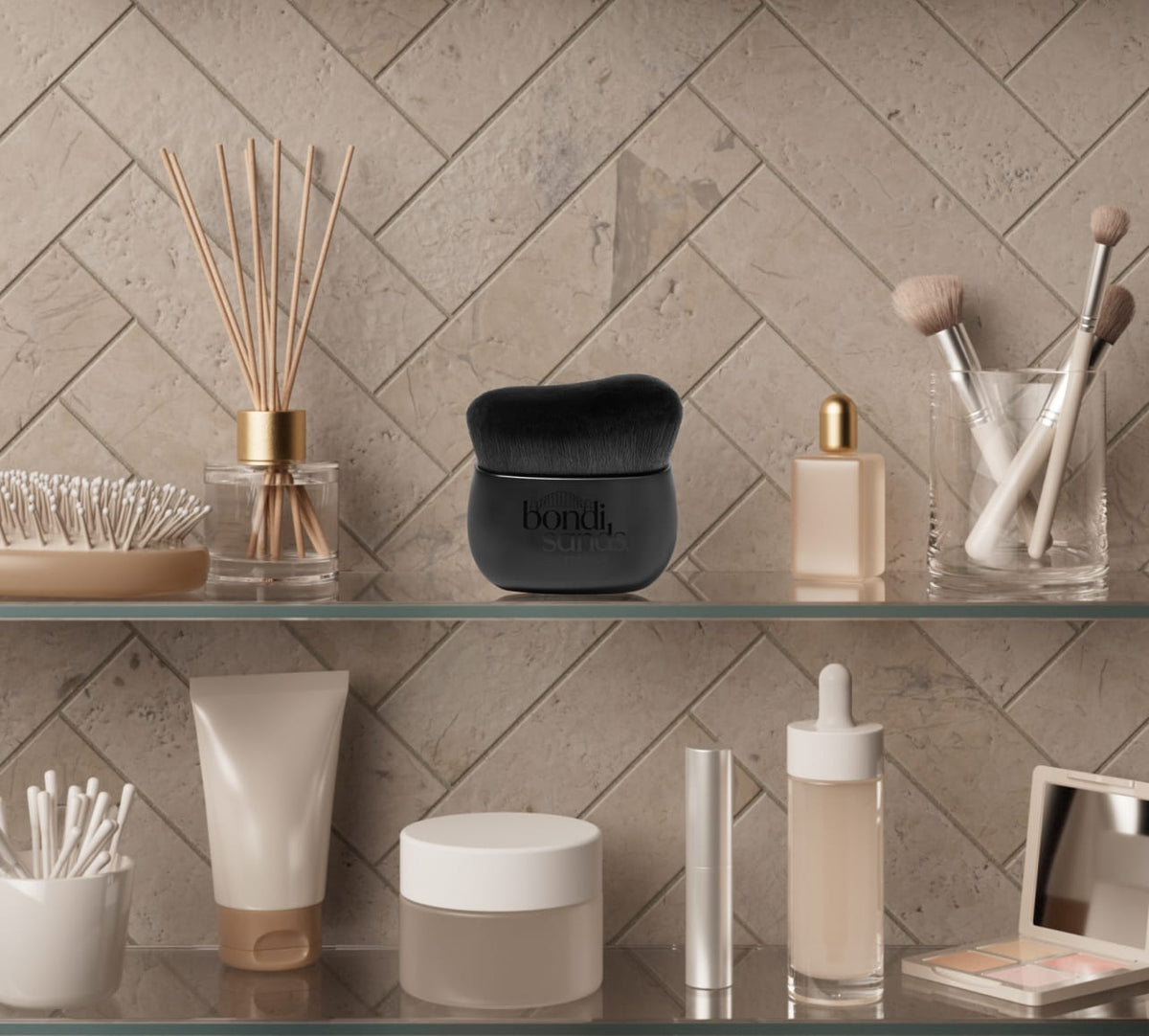 A bathroom shelf displays beauty essentials—a Body Brush and black jar, both by BondiSandsEU, along with makeup brushes, bottles, tubes, a reed diffuser, and a tanning mitt—arranged against a beige herringbone tile wall for a radiant glow.