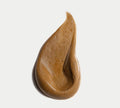A smooth, airy brown cream—like self tanning foam—is spread in a teardrop shape on a white background, showing its glossy texture. Featured: BondiSandsEU Dark Self Tanning Routine Bundle.