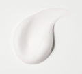 A close-up of a smooth, white BondiSandsEU Self Tan Eraser exfoliating foam swatch forms a curved, teardrop-like shape on a plain white background.