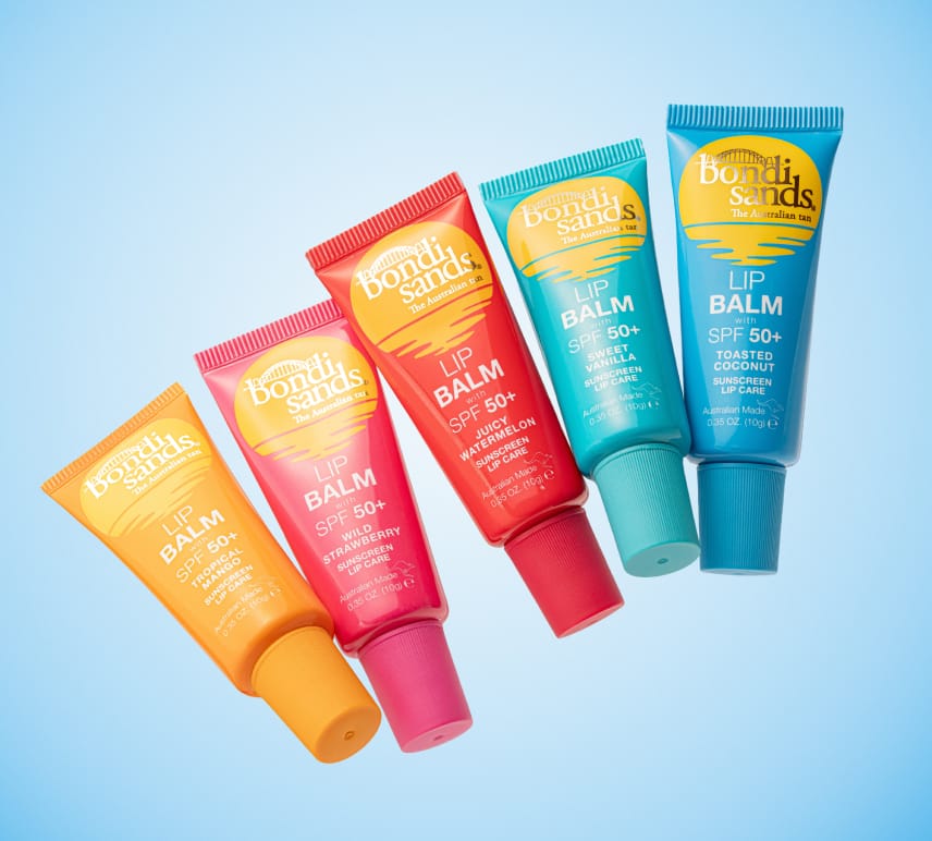 Five vibrant tubes of BondiSandsEU Watermelon SPF 50+ Lip Balm, enriched with Shea Butter, lie diagonally on a blue background in yellow, pink, red, green, and blue.