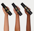 Three hands of varying skin tones each hold a black BondiSandsEU Liquid Gold Gift Set bottle against a plain white background.