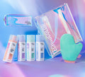 BondiSandsEU’s Emerald Technocolor 1 Hour Express Self Tanning Foam for medium skin tones, shown with four bottles, an applicator mitt, a clear iridescent tote bag, and a smaller pouch on a pastel gradient background.