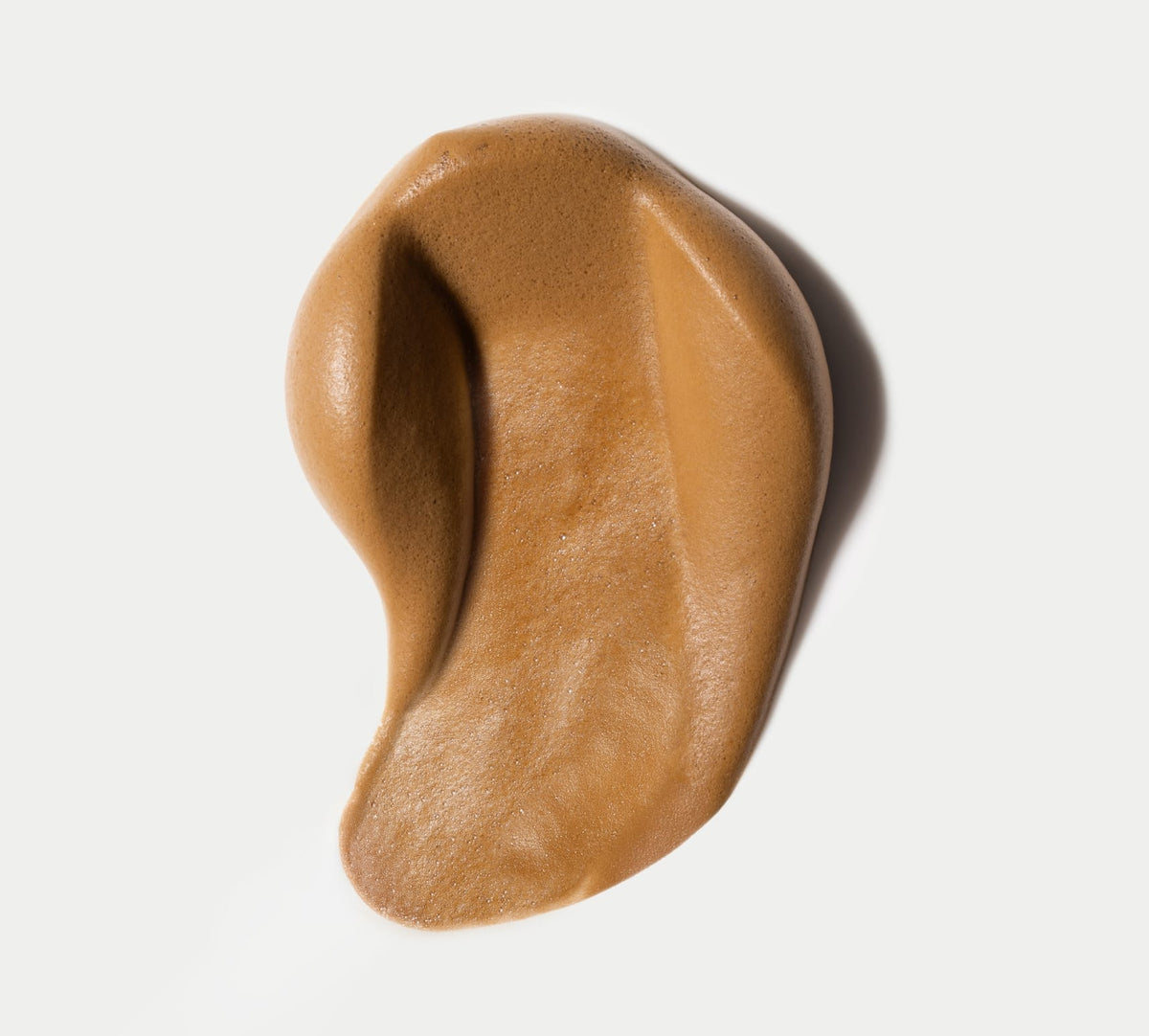 Aero Express Self Tanning Routine Bundle by BondiSandsEU: a creamy caramel mousse, artfully smeared on white in a teardrop shape—ideal for flawless results when used with the included application mitt.