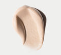A smooth, creamy beige swatch of BondiSandsEU Liquid Gold Aero Self Tanning Mousse Bundle is spread in an organic curve on a white background, highlighting its soft texture.