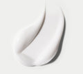 BondiSandsEU Gradual Self Tanning Face Lotion is shown as a smooth, white smear on a light gray background, highlighting its glossy texture and soft curves; dermatologist approved and non-comedogenic.
