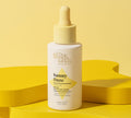A bottle of BondiSandsEU Sunny Daze Hydrating SPF 50+ Face Fluid Drops with a yellow cap and label accents stands on a bright yellow background, creating a clean, summery vibe.
