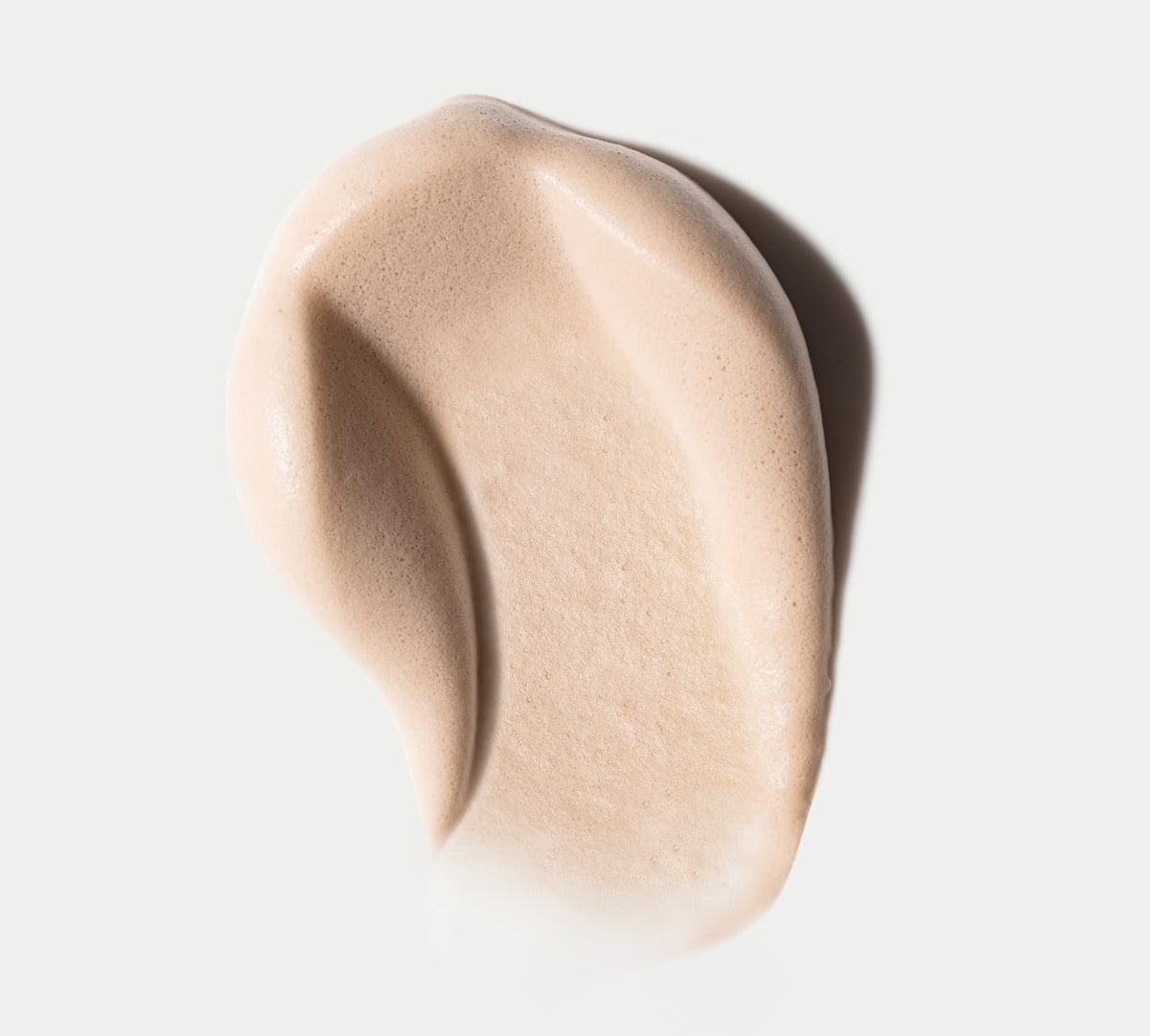 A close-up of BondiSandsEU's Liquid Gold Aero Self Tanning Mousse & Application Mitt Bundle, showcasing the smooth, whipped formula in an abstract shape on a white background for a flawless, streak-free tan.