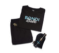 The BondiSandsEU Bondi Babe Short Tanning PJs set includes folded black pyjamas with "Bondi Babe" in blue and white, matching shorts, a Bondi Sands self tanning foam bottle, and a black tanning mitt, all on a white background.