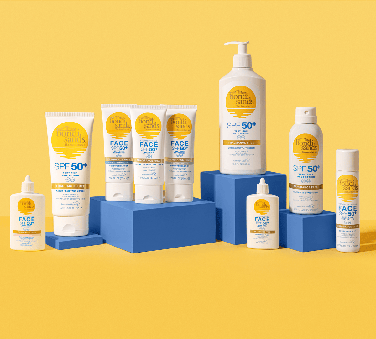 BondiSandsEU SPF 50+ Everyday Hydrating Tinted Face Lotion is displayed on blue blocks against a yellow background, featured among other Bondi Sands sunscreens for face and body in bottles, tubes, and sprays.