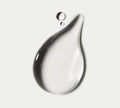 A large, clear drop of BondiSandsEU Light-Medium Self Tanning Face Drops, glossy with tiny air bubbles, and two smaller drops rest on a plain white background.