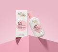 A pink and white bottle of BondiSandsEU Baby Face Retinol Serum sits beside its matching box on a pink surface and background—formulated to help reduce fine lines for youthful-looking skin.