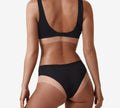 A person in black bra and underwear, seen from behind with tan lines—highlighting results from a BondiSandsEU Liquid Gold Salon Solution Bundle tanning session. The background is plain white.