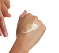A close-up shows Skin Illuminator Gradual Tanning Lotion by BondiSandsEU being applied to skin, with one hand ready to spread the tan on the back of the other, all set against a white background for a naturally glowing look.