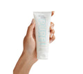 A hand holds a white tube of BondiSandsEU Pure Self Tanning Sleep Mask for sensitive skin with blue and silver text, hyaluronic acid, set against a clean white background.