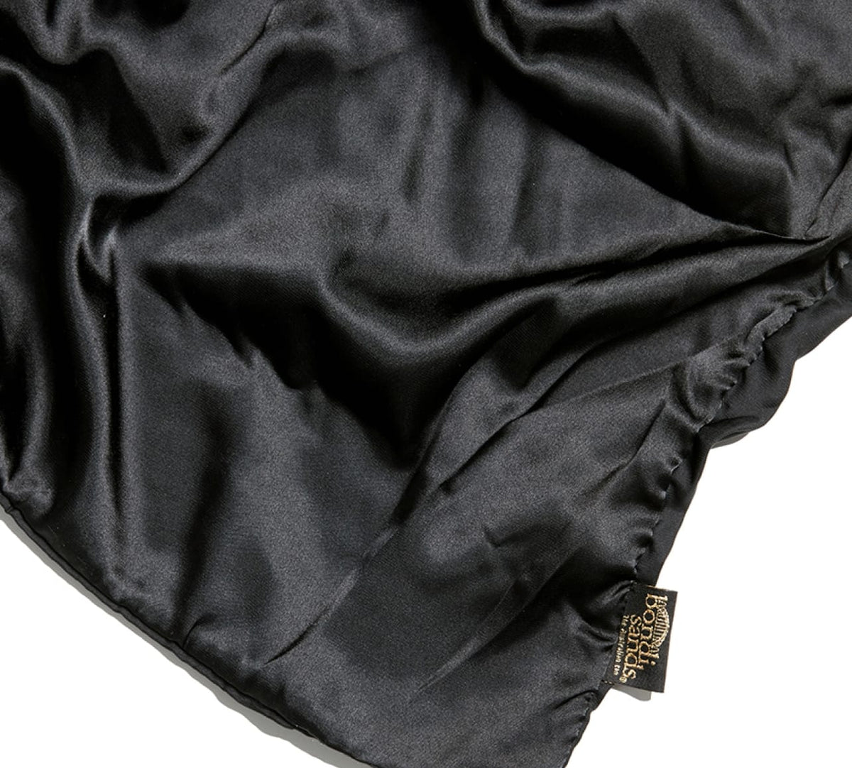 A close-up of the shiny black BondiSandsEU Self Tanning Sheet Protector, perfect for your tanning routine, featuring a brown and gold Posh Silk Studio tag in the bottom corner.