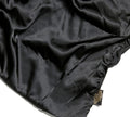A close-up of the shiny black BondiSandsEU Self Tanning Sheet Protector, perfect for your tanning routine, featuring a brown and gold Posh Silk Studio tag in the bottom corner.