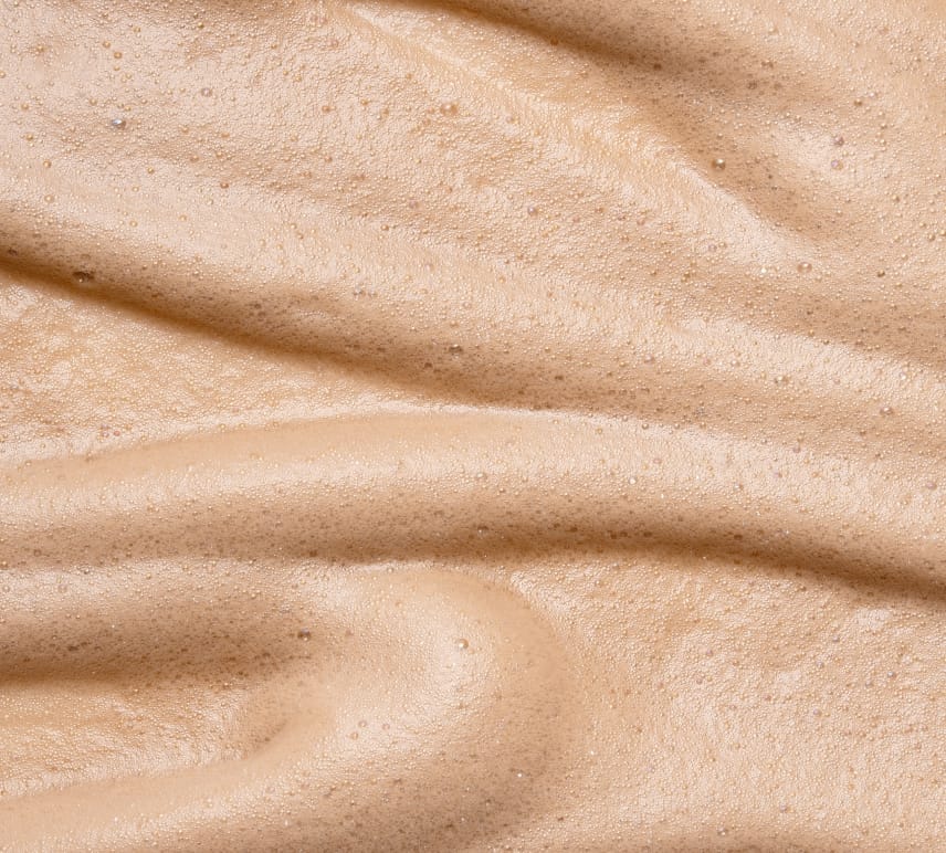 Close-up of BondiSandsEU Liquid Gold Aero Self Tanning Mousse—a light brown, airy formula with a smooth, foamy texture and swirling patterns—ideal for anyone seeking a luxurious self-tanning experience.