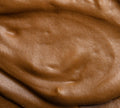 Close-up of BondiSandsEU Express Aero Self Tanning Mousse, featuring a smooth, creamy texture and deep bronze color with glossy swirls and peaks, resembling rich chocolate mousse.