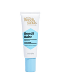 A white tube with a blue cap labeled BondiSandsEU Bondi Babe Clay Mask. Features gold and black text, a blue section near the base, and purifies skin with blue spirulina for a radiant glow.