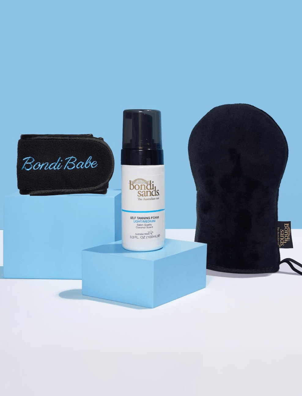 The Bondi Sands Europe Light-Medium Get Glowing 3 Piece Starter Kit is displayed on blue blocks against a blue background—your essentials for achieving a flawless, streak-free tan.