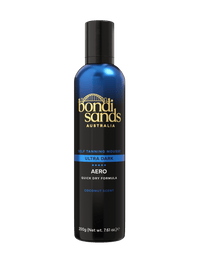 A blue and black bottle of BondiSandsEU Ultra Dark Aero Self Tanning Mousse, adorned with bold gold text and a coconut scent label, is displayed against a plain white background. This quick-drying self tanning mousse delivers an ultra dark finish for a flawless, bronzed appearance.