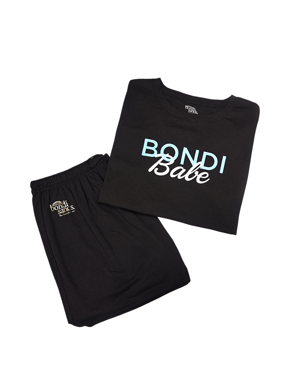 The BondiSandsEU Bondi Babe Short Tanning PJs feature a folded black T-shirt with “Bondi Babe” in blue and white, paired with matching black shorts adorned with a small Bondi Sands logo on the left leg. Displayed together on a white background, this loungewear set is perfect for relaxing at home or slipping into after applying self tan.