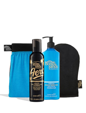 BondiSandsEU’s Aero Liquid Gold Self Tanning Routine Bundle includes a blue exfoliating mitt, black tanning mitt, Aero foam in a black bottle, and gradual tanning milk with pump in a blue bottle for your self-tanning routine.