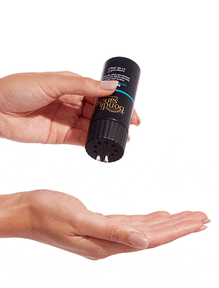 A person taps BondiSandsEU Self Tan Drying Powder & Brush Bundle over their open palm, applying the powder for a flawless tan.