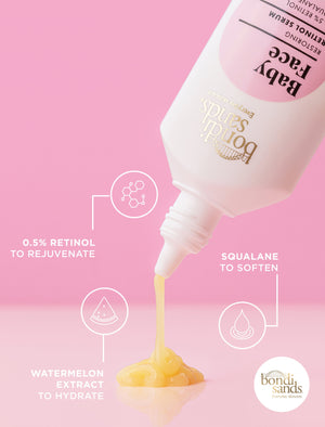 A bottle of BondiSandsEU Baby Face Retinol Serum with yellow serum pouring out, featuring 0.5% retinol to rejuvenate, squalane to soften, and watermelon extract for hydration—promoting youthful skin and fewer fine lines on a pink background.