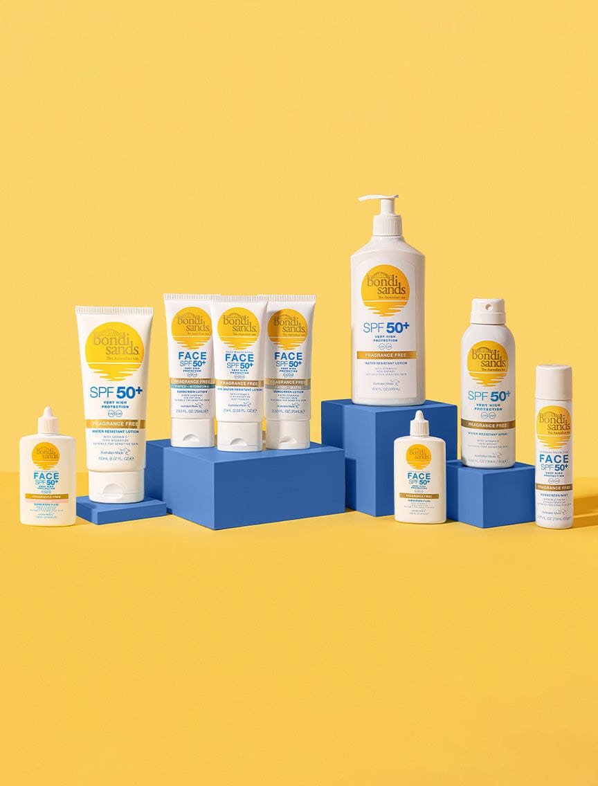 A lineup of BondiSandsEU Face SPF 50+ Tinted & Matte Sunscreen Lotion, featuring yellow and white packaging, is arranged on blue blocks against a yellow backdrop. The bottles highlight SPF 50+, ideal for oily skin protection.