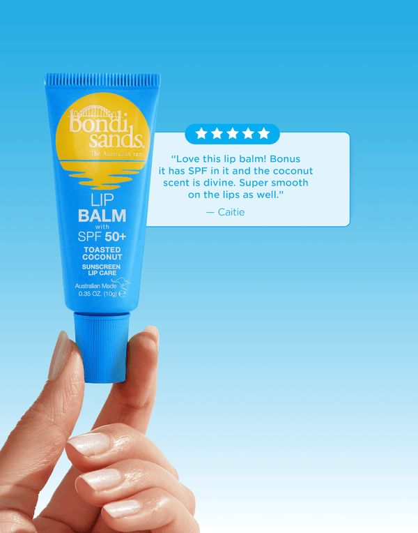 A hand holds a blue tube of BondiSandsEU SPF 50+ Lip Balm Toasted Coconut against a blue background, with a customer review beside it highlighting its hydrating power and strong sun protection for lips.