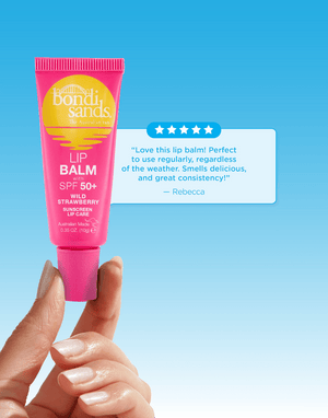 A hand holds a pink tube of BondiSandsEU SPF 50+ Lip Balm Wild Strawberry with nourishing Shea Butter against a blue gradient background, alongside a glowing customer review highlighting its hydrating sun protection.