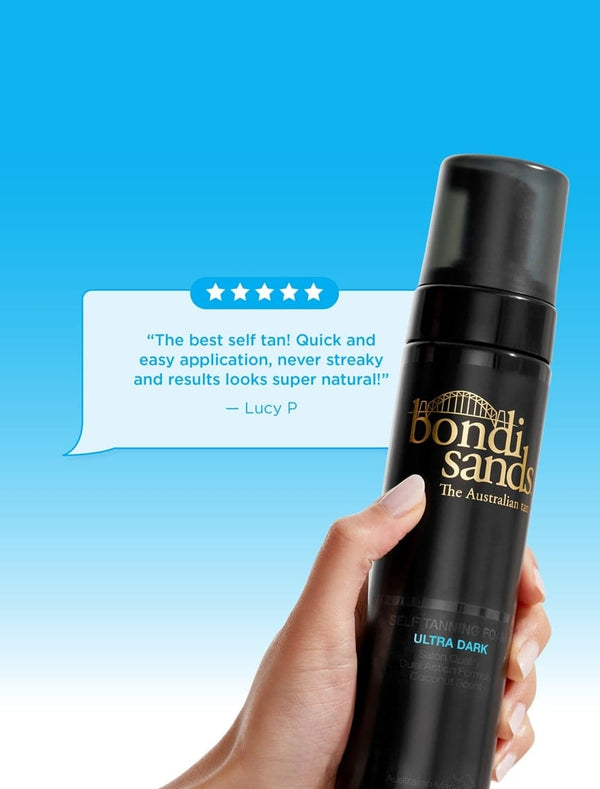 A hand holds BondiSandsEU Self Tanning Foam Ultra Dark. Above, a review says: “The best self tan! Quick and easy application, never streaky and results look super natural!” — Lucy P. A blue background shows a review graphic.