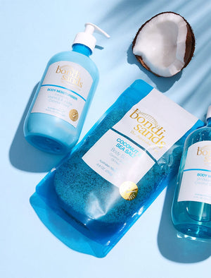 Bondi Sands Coconut Scented Body Moisturiser and Sea Salt Exfoliating Scrub Flat Lay with Coconut Fruit